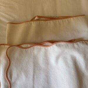 Ivory matelasse coverlet with peach trim and monogram